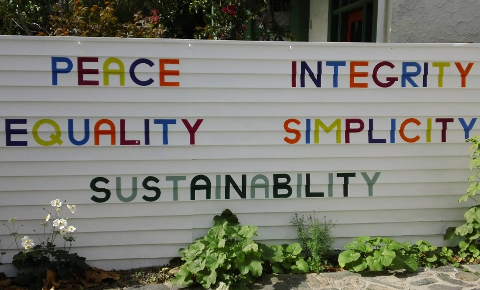 White sign with five words in colourful capital letters: PEACE INTEGRITY EQUALITY SIMPLICITY SUSTAINABILITY